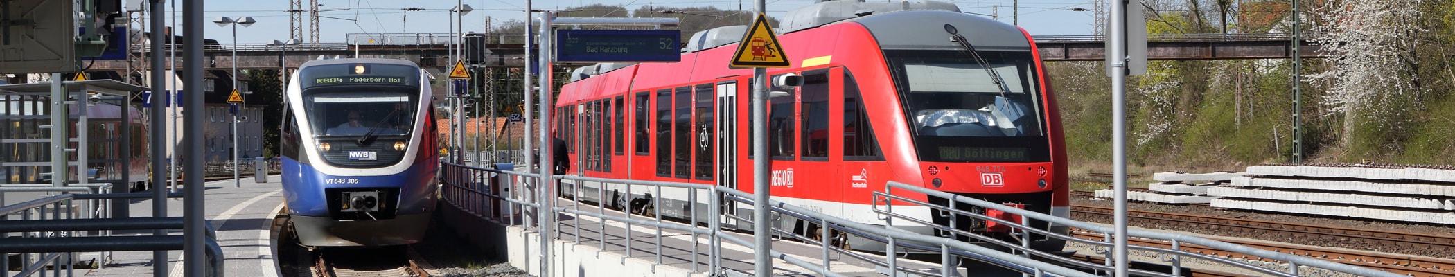 Roter DB Zug und ZUg der Nord WestBahn stehen auf gleicher Höhe in einer Station